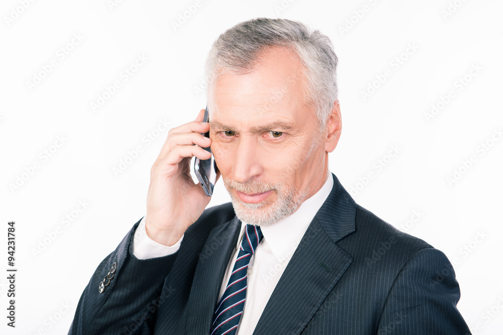 Old intelligent businessman talking on the phone Old intelligent businessman talking on the phone