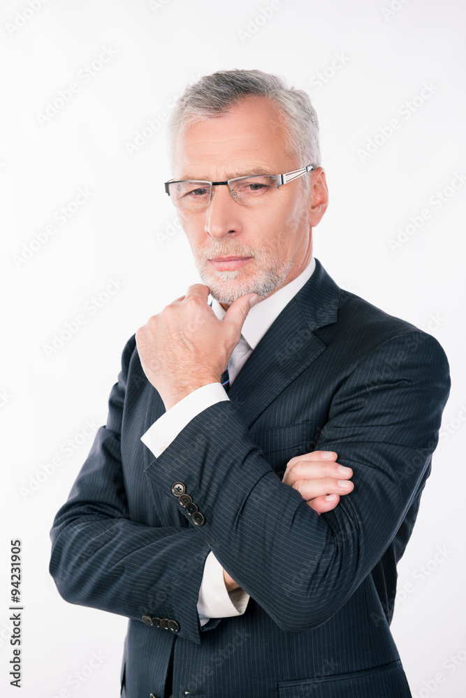 Old intelligent businessman with glasses ponders putting his han Old intelligent businessman with glasses ponders putting his han
