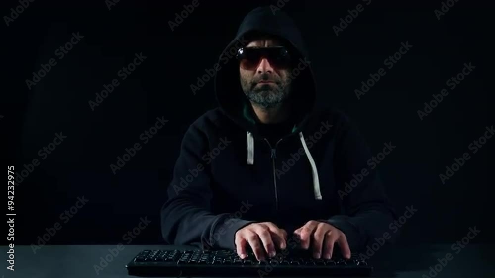 Hacker typing on keyboard in black room Hacker typing on keyboard in black room