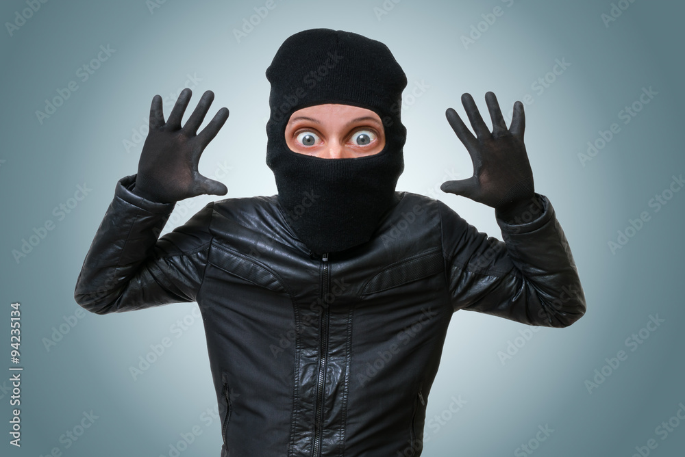 Funny childlike burglar or bandit puts hands up. Funny childlike burglar or bandit puts hands up.