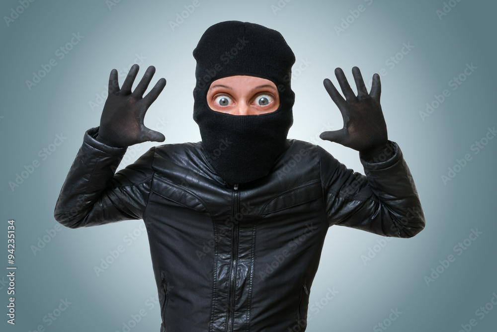 Funny childlike burglar or bandit puts hands up.