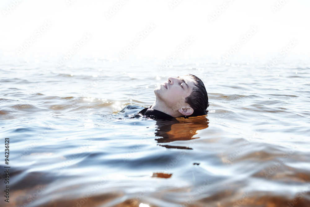 Fototapeta premium Sinking in the problems. Young man experiencing pain and