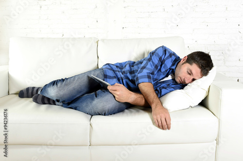 young attractive man sleeping at home couch relaxing after working with digital tablet pad © Wordley Calvo Stock