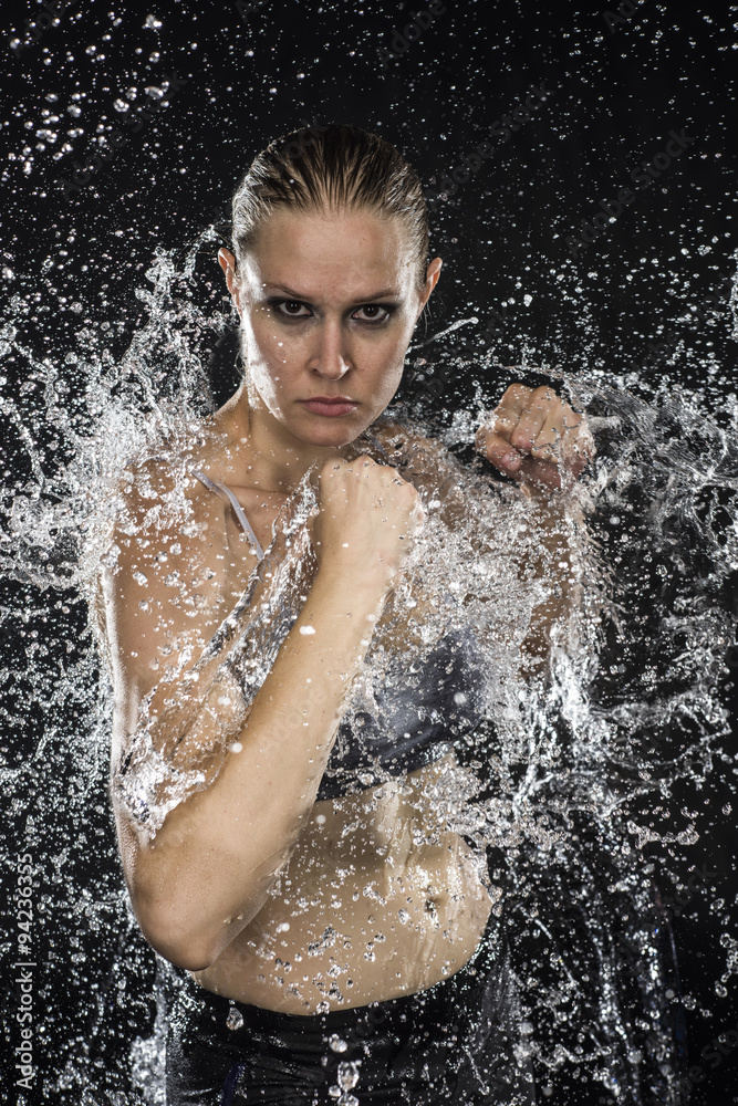Obraz premium Female Fighter in Water Splashes Looking Fierce