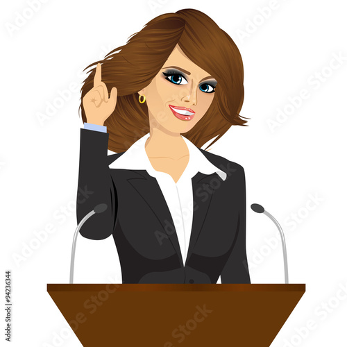female orator standing behind a podium with microphones