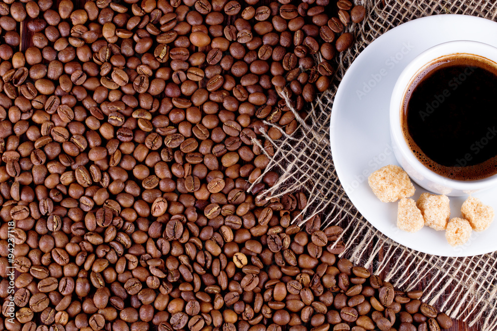 Coffee cup on a saucer and coffee grains