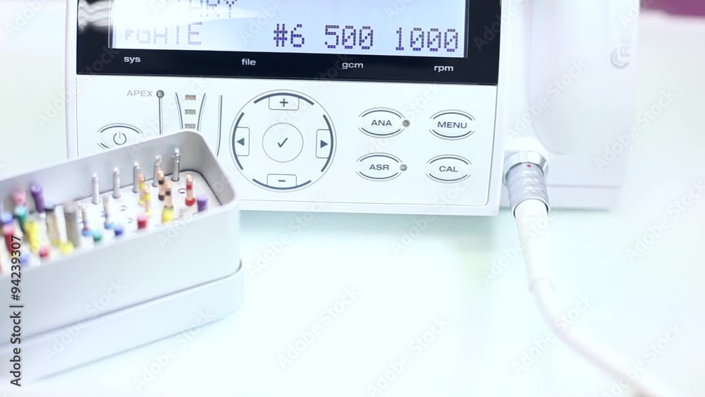 Set of dental carbide bur tools on white countertop over white dentist machine / camera moving right / close-up Set of dental carbide bur tools on white countertop over white dentist machine / camera moving right / close-up