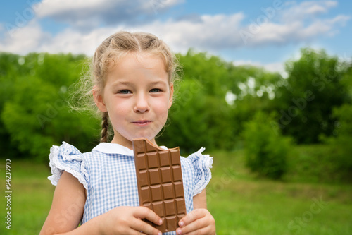 Little girl with pleasure is chocolate