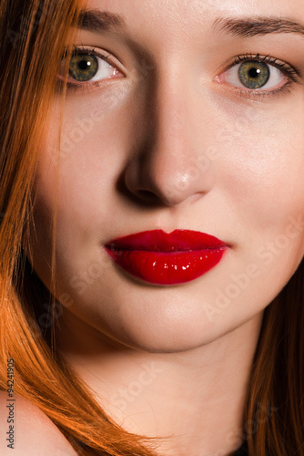 Portrait of red-haired girl with green eyes and red lips 