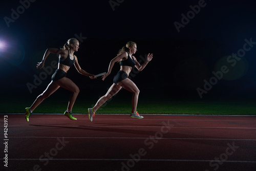 athletic runners passing baton in relay race © .shock