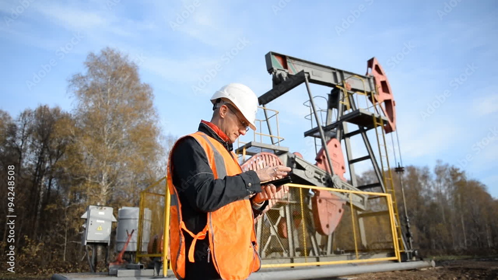 custom made wallpaper toronto digitalMan (Engineer, Manager, Supervisor, oilman) with tablet computer inspects the oil pumping unit.