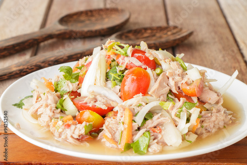 Spicy Tuna Salad onion and tomatoes in plate put on wooden background , Thailand cuisine.