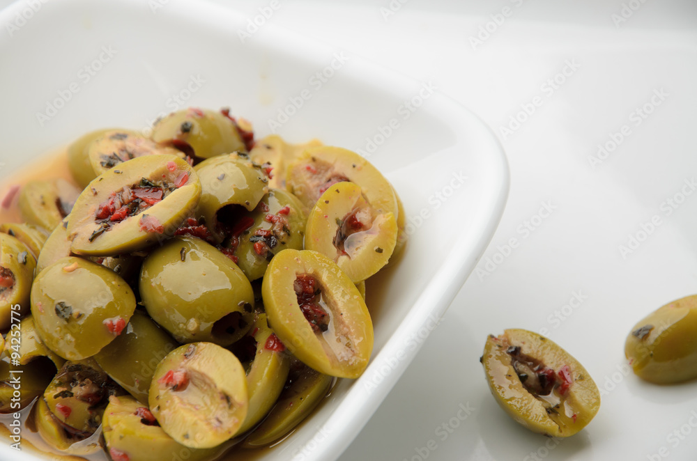 Split olives in white bowl Split olives in white bowl