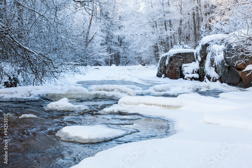 River with snow and ice in the winter woods photo