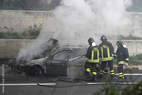 burning car with firefighters