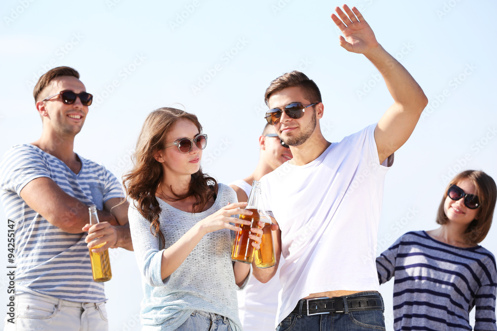 Young people with beer on the riverside Young people with beer on the riverside