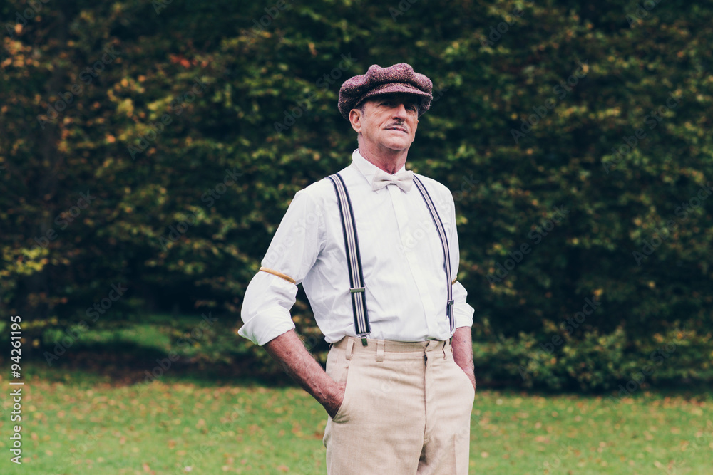 Senior retro fashion man standing in garden. Senior retro fashion man standing in garden.