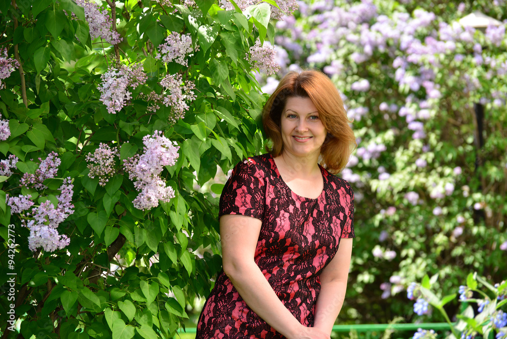 Middle-aged woman near blossoming lilac Middle-aged woman near blossoming lilac