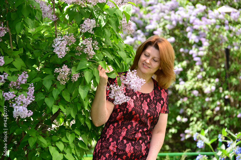 Middle-aged woman near blossoming lilac Middle-aged woman near blossoming lilac