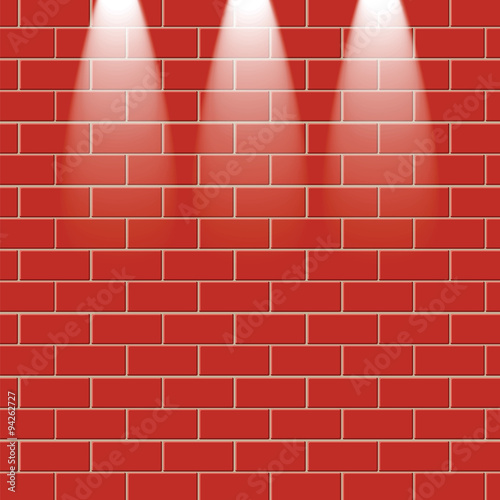 Red brick wall is illuminated by the rays of light