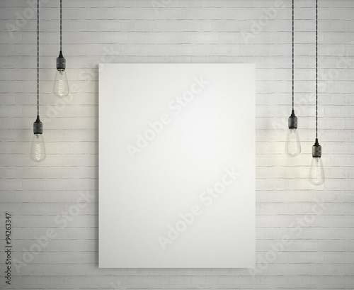 Blank white poster on brick wall hanging under decorative vintage light bulbs photo