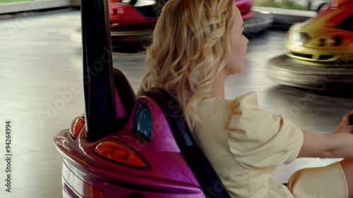 Smile mother with her daughter drive on bumper cars in Amusement