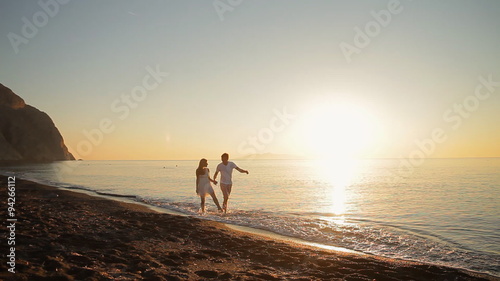 beautiful couple walking along the shore of the Aegean Sea