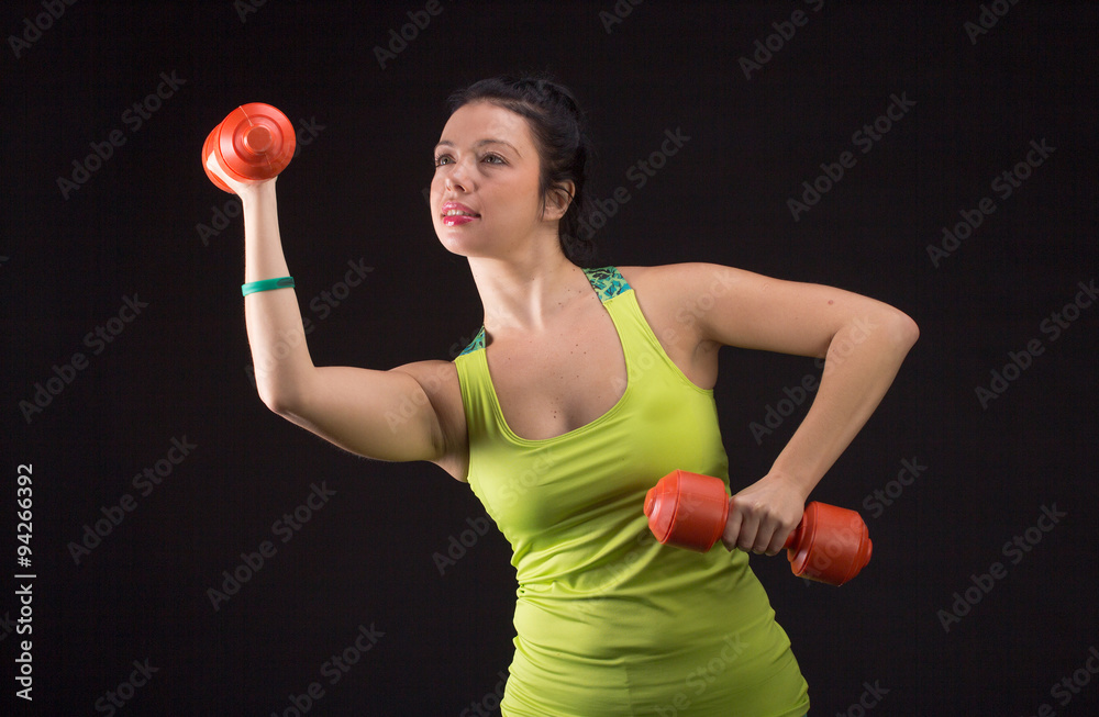 Portrait of smiling woman lifting dumbbells