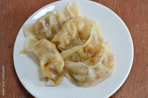 vegetarian steamed Chinese dumpling dressing soy sauce on dish photo