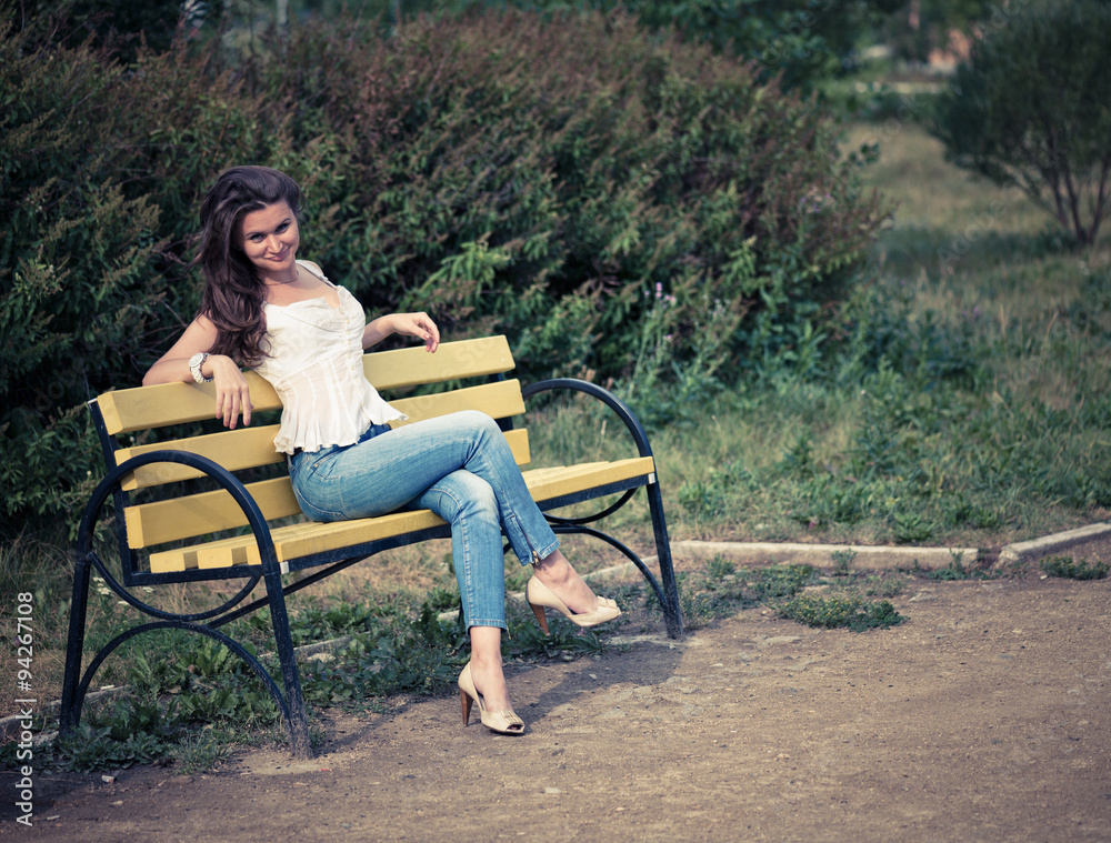 beautiful woman sit on a bench in park