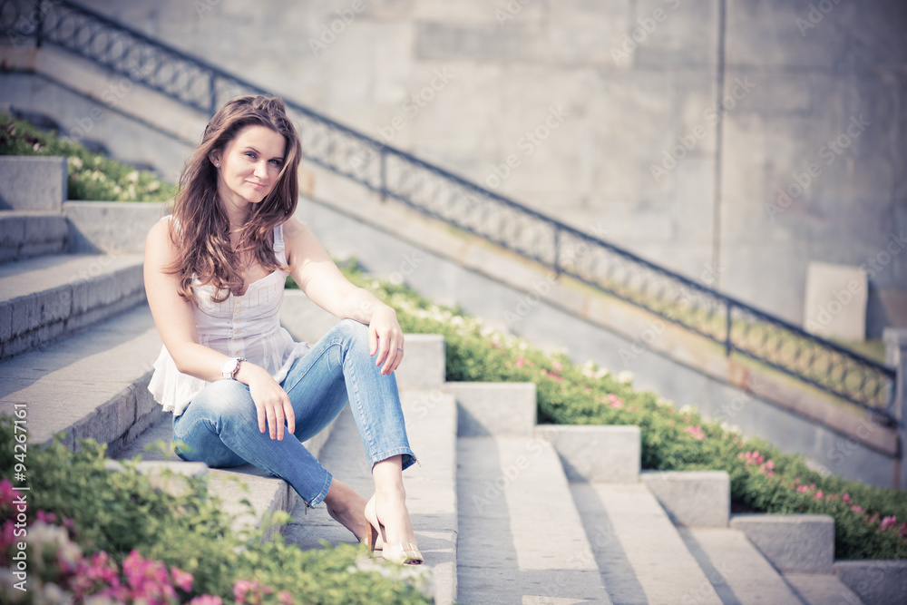 Portrait of a beautiful european woman sitting om steps