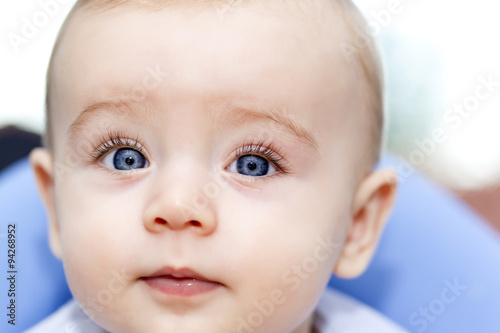 Headshot of a baby with blue eyes looking to the camera