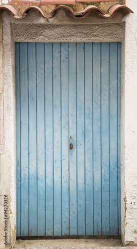 Old blue rusty door texture as a background, front view, vertica