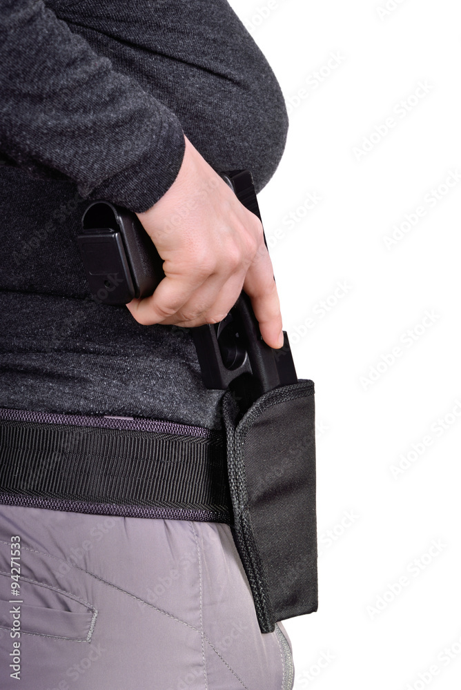 Puts the gun in the holster foto de Stock Adobe Stock