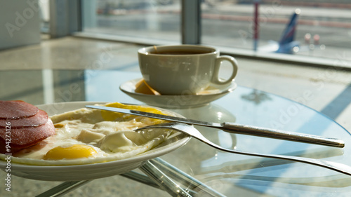 Cup of tea .scrambled eggs and sausage in airport s business lounge while waiting for the flight
