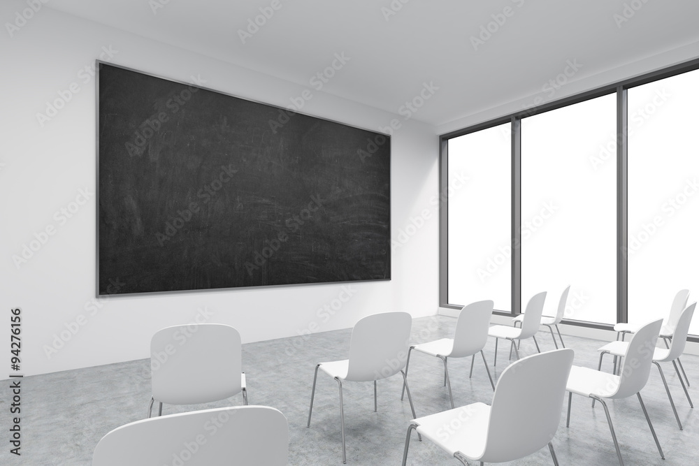 A classroom or presentation room in a modern university or fancy office. White chairs, panoramic windows with white copy space and a black chalkboard on the wall. 3D rendering.