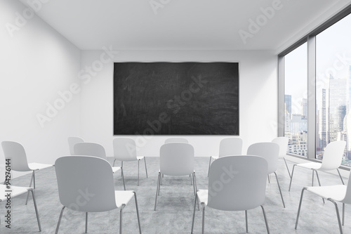 A classroom or presentation room in a modern university or fancy office. White chairs, a black chalkboard on the wall and panoramic New York view. 3D rendering.