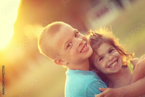 Brother and sister in hug with love and big happy smile. Shalow photo