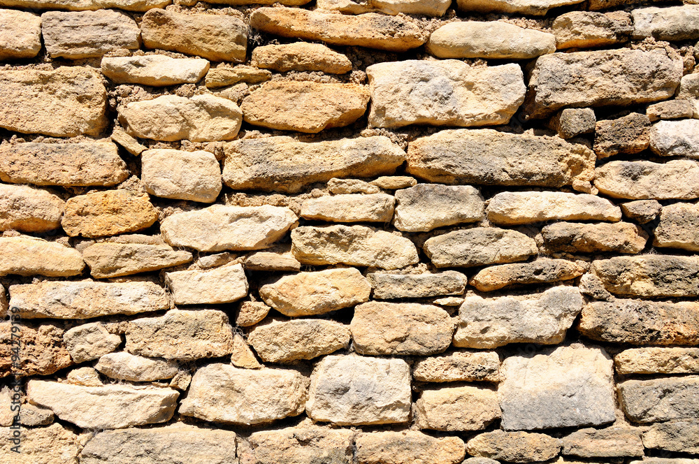 Old ramshackle stone wall in medieval french village. Old ramshackle stone wall in medieval french village.
