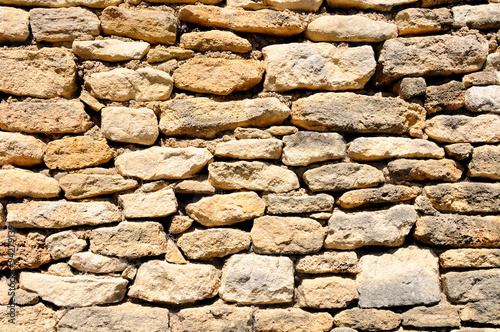 Bild auf Leinwand Old ramshackle stone wall in medieval french village for image background use