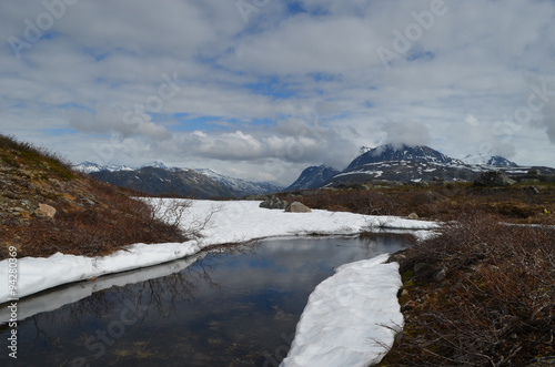 River lined with snow in subarctic alpine tundra, Norwegian mountains