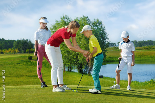 Trainer works with children at golf school
