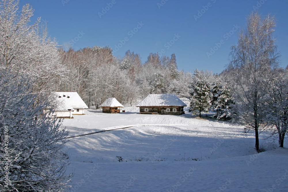 Snow-covered houses are rustic in the woods among the trees and Snow-covered houses are rustic in the woods among the trees and