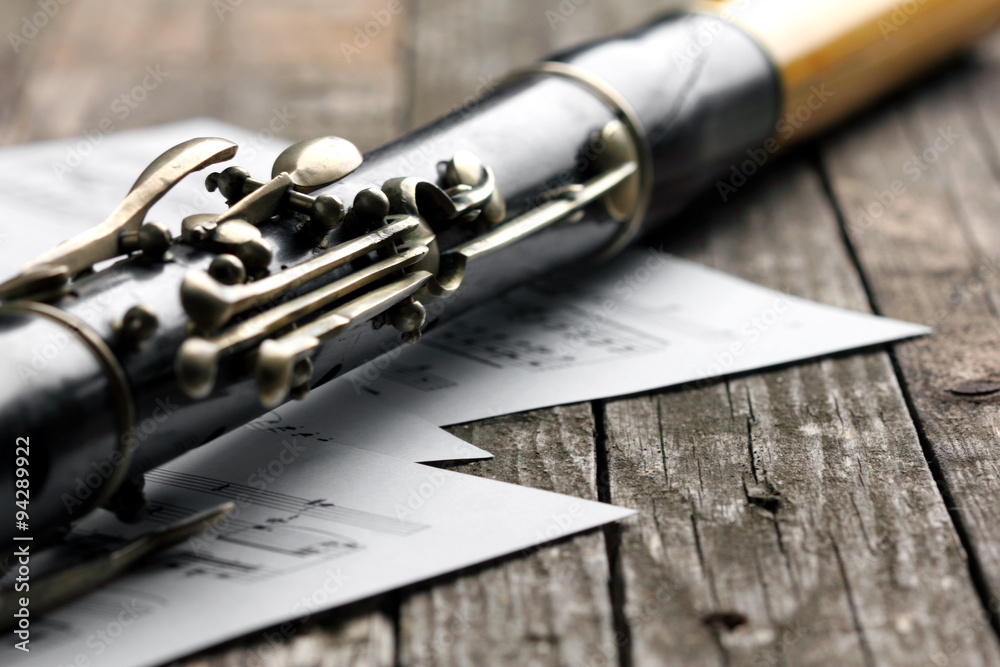 Naklejka premium Old black flute and music notes on rusty wooden table