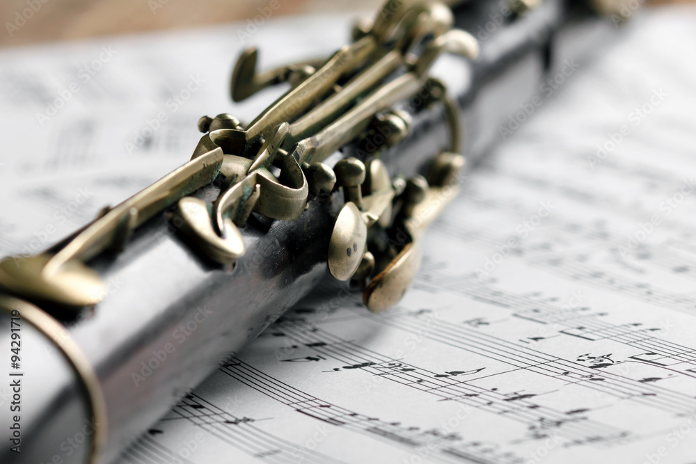 Obraz premium Old black flute and music notes on rusty wooden table
