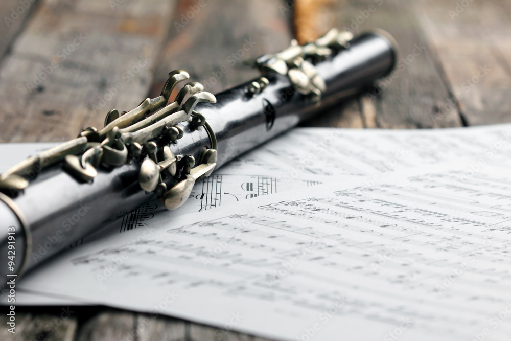 Naklejka premium Old black flute and music notes on rusty wooden table