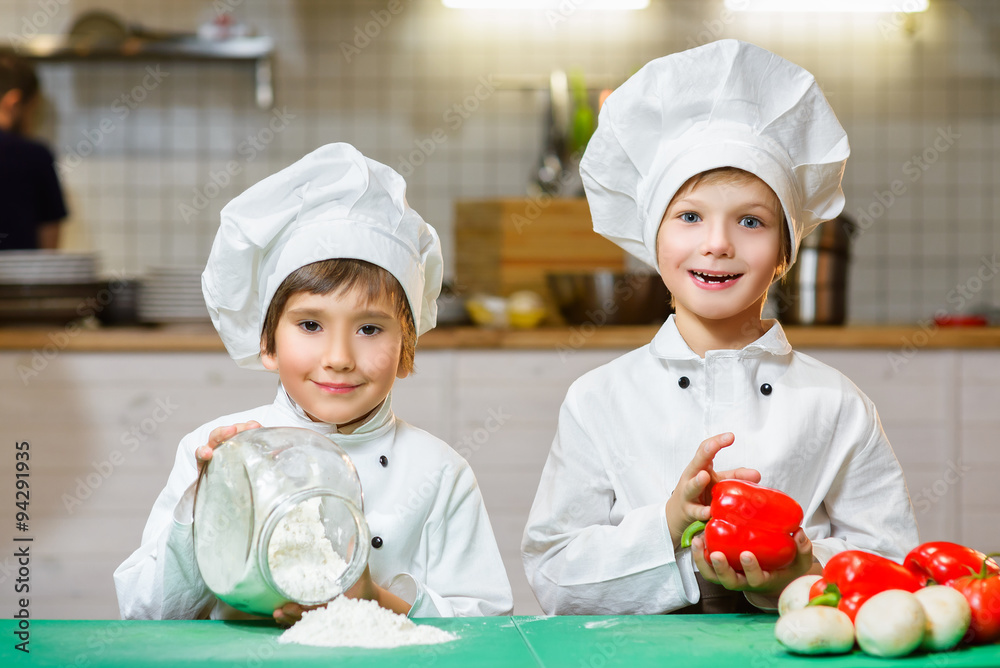 Funny happy chef boys cooking at restaurant kitchen Funny happy chef boys cooking at restaurant kitchen