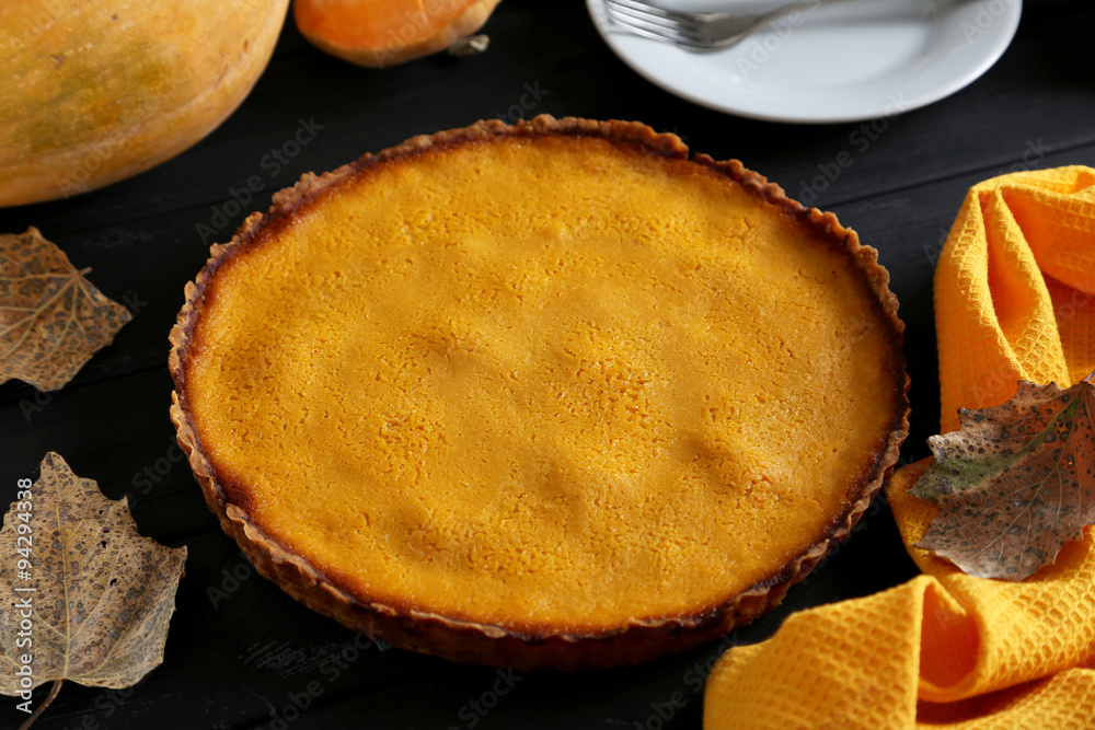 Tasty pumpkin pie on a black wooden table
