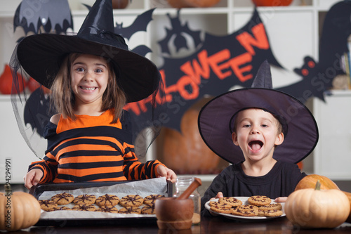 Kids eating halloween coockies on a party photo