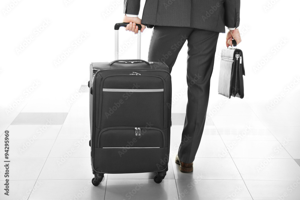 Man holding suitcase on light background Man holding suitcase on light background